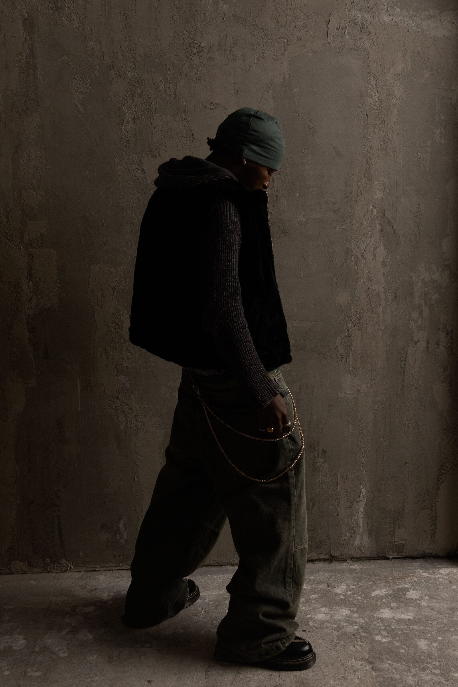 Person in a dark layered streetwear silhouette