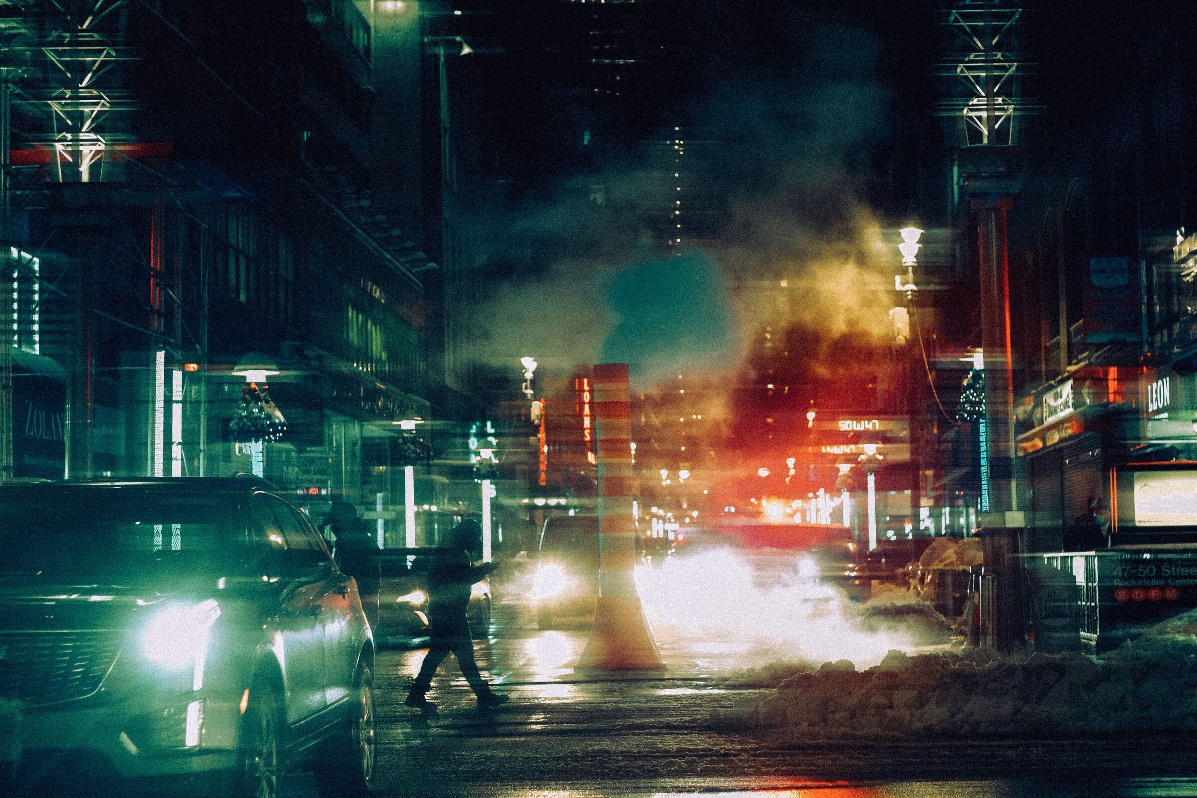 Blurred figures and traffic moving through a city at night